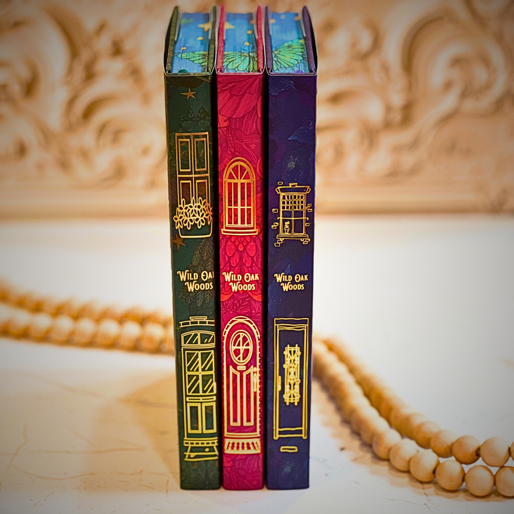 Three books titled 'Wild Oak Woods' with colorful covers on a decorative surface.