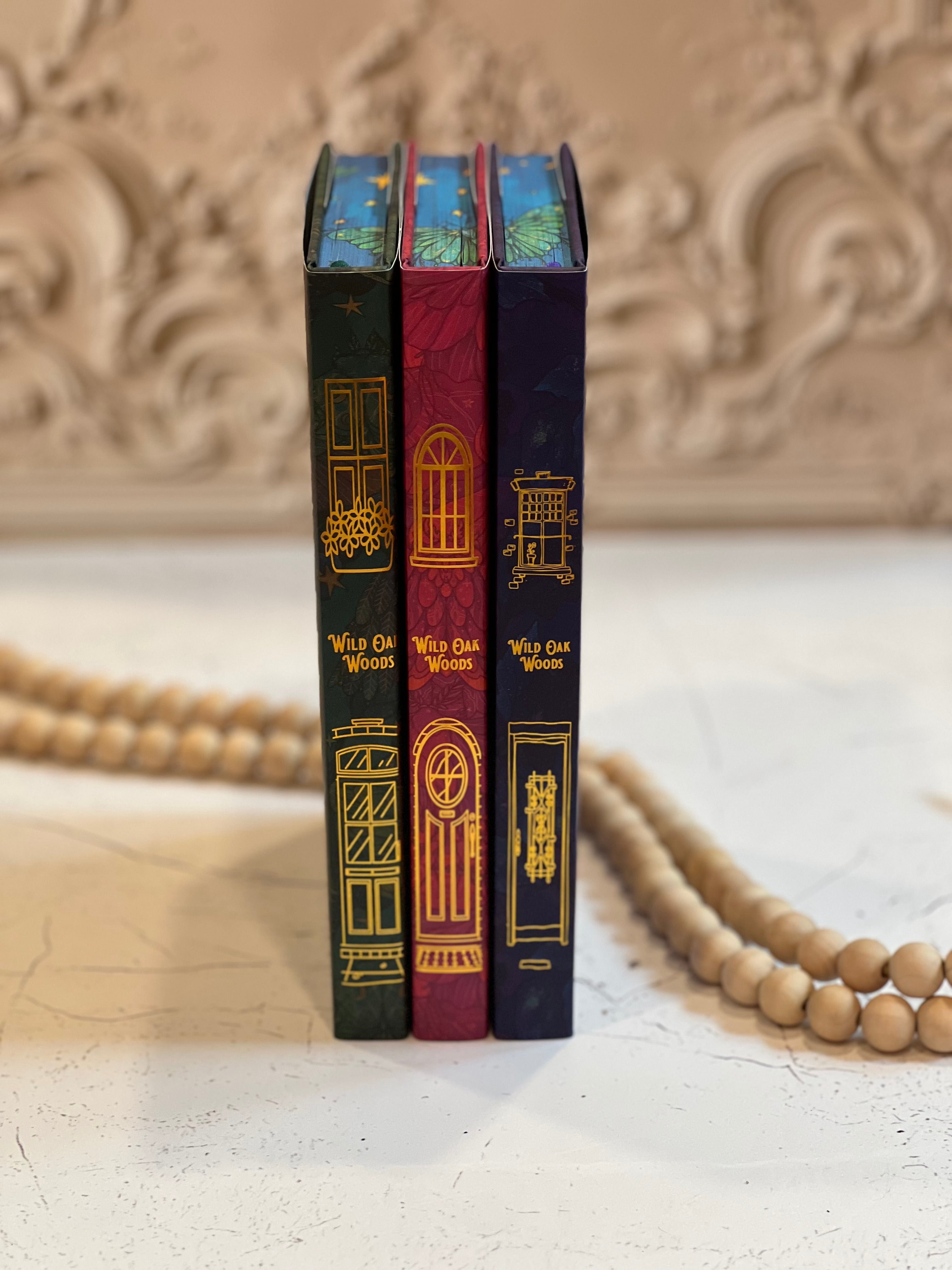Three books with decorative spines on a textured surface.