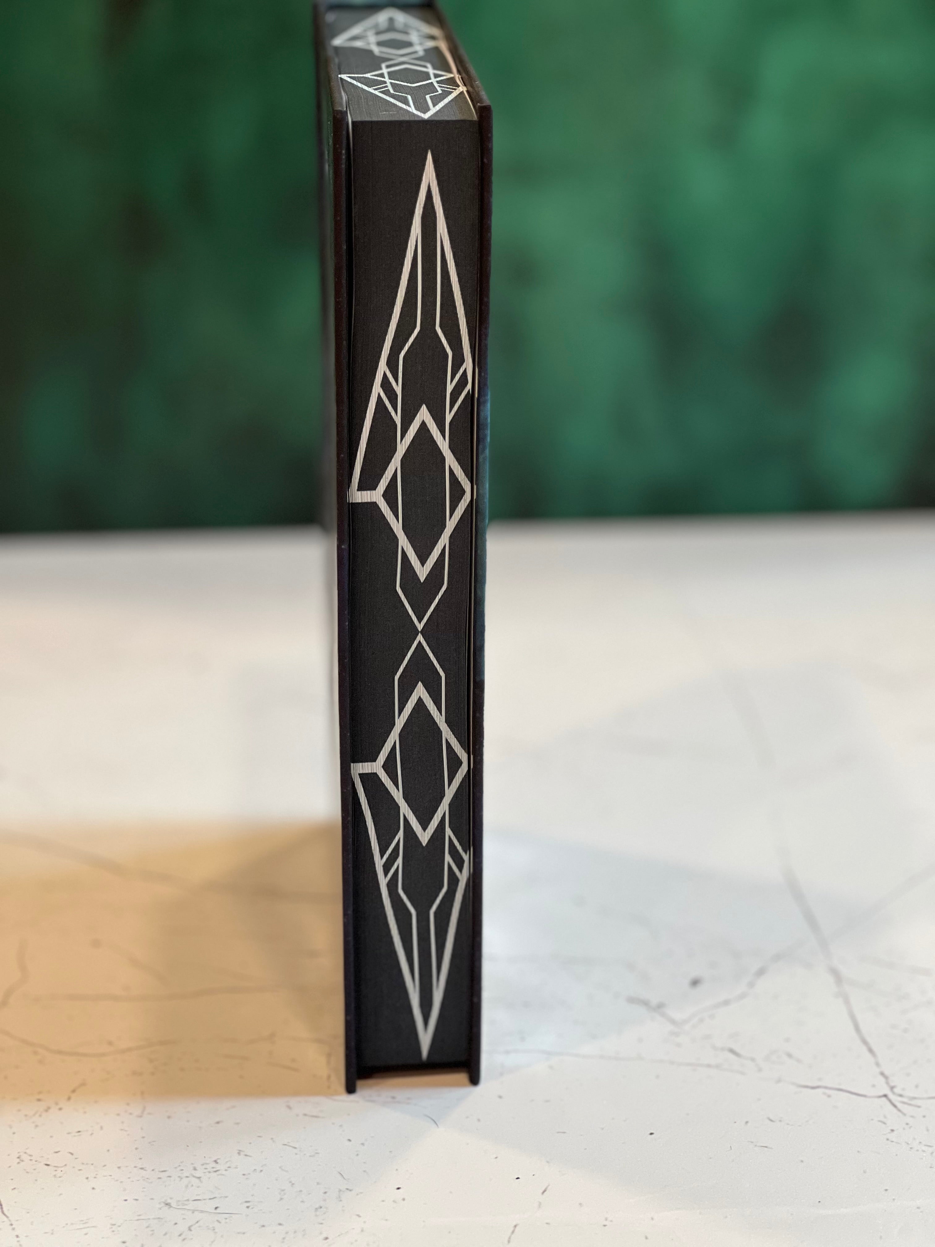 Black box with geometric design on a white surface with green background
